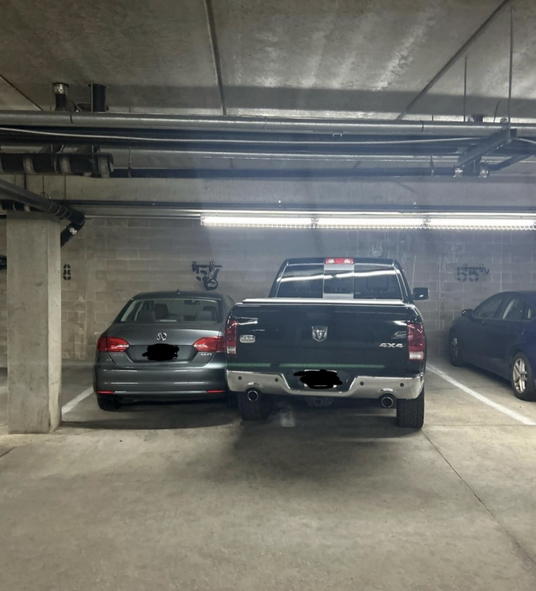 truck parked diagonally in two spots and a car in their parking spot right next to it