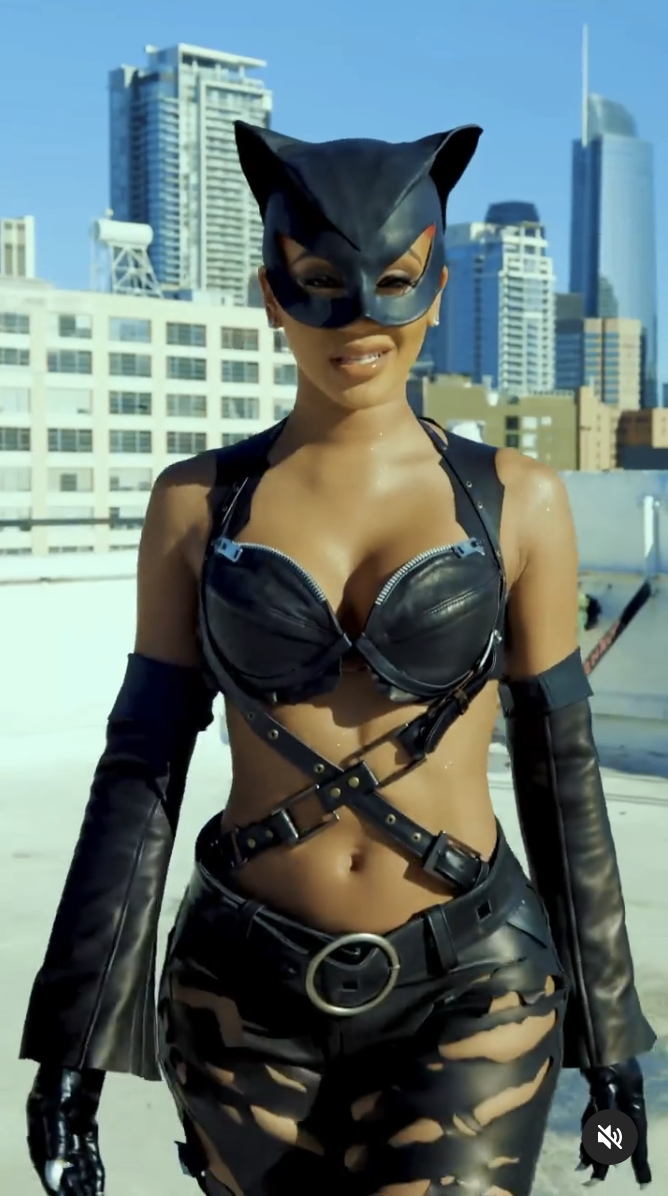 closeup of her in cutout leather outfit and cat face mask