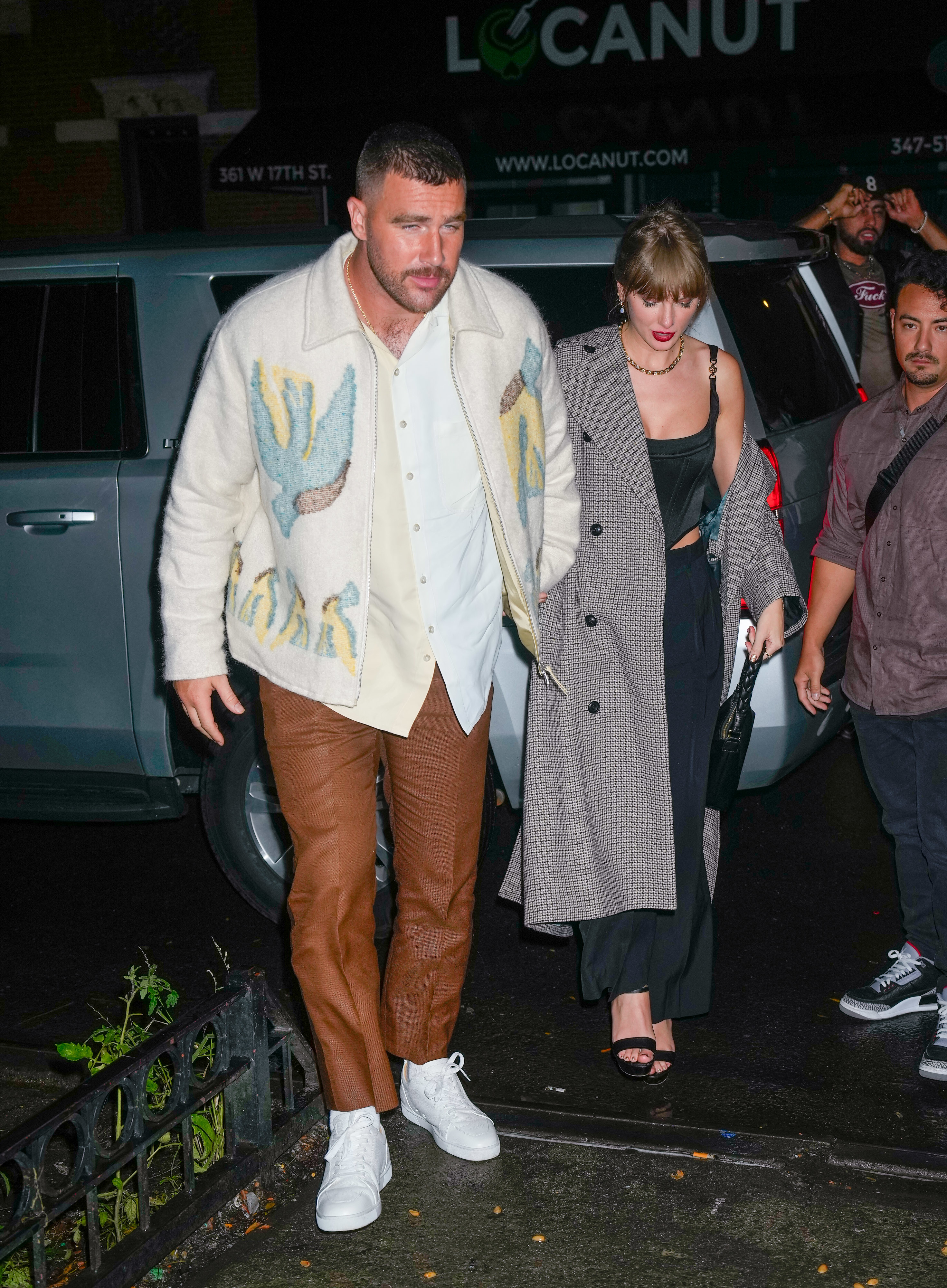 the two holding hands as they arrive somewhere at night