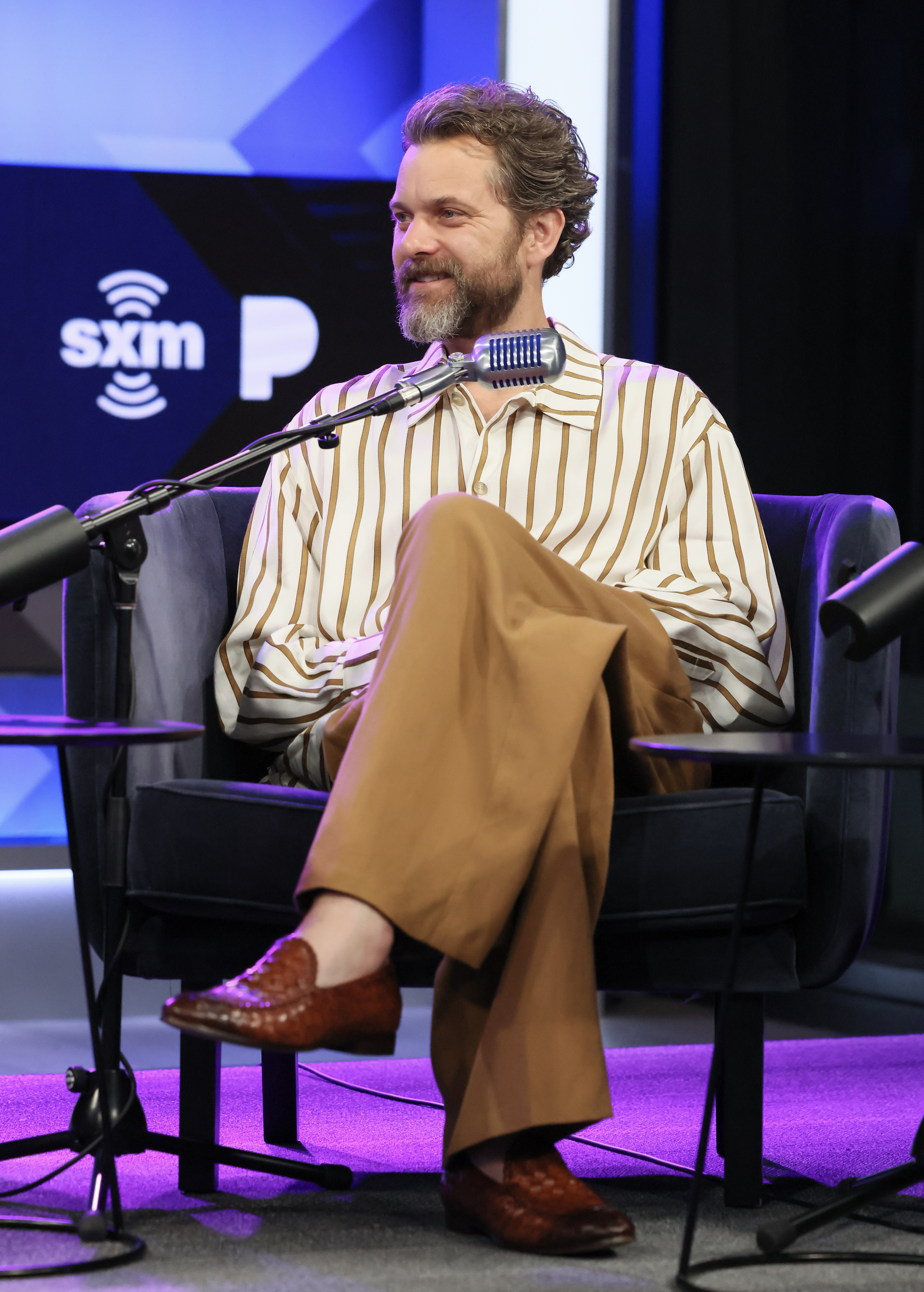 closeup of him sitting for an interview on stage