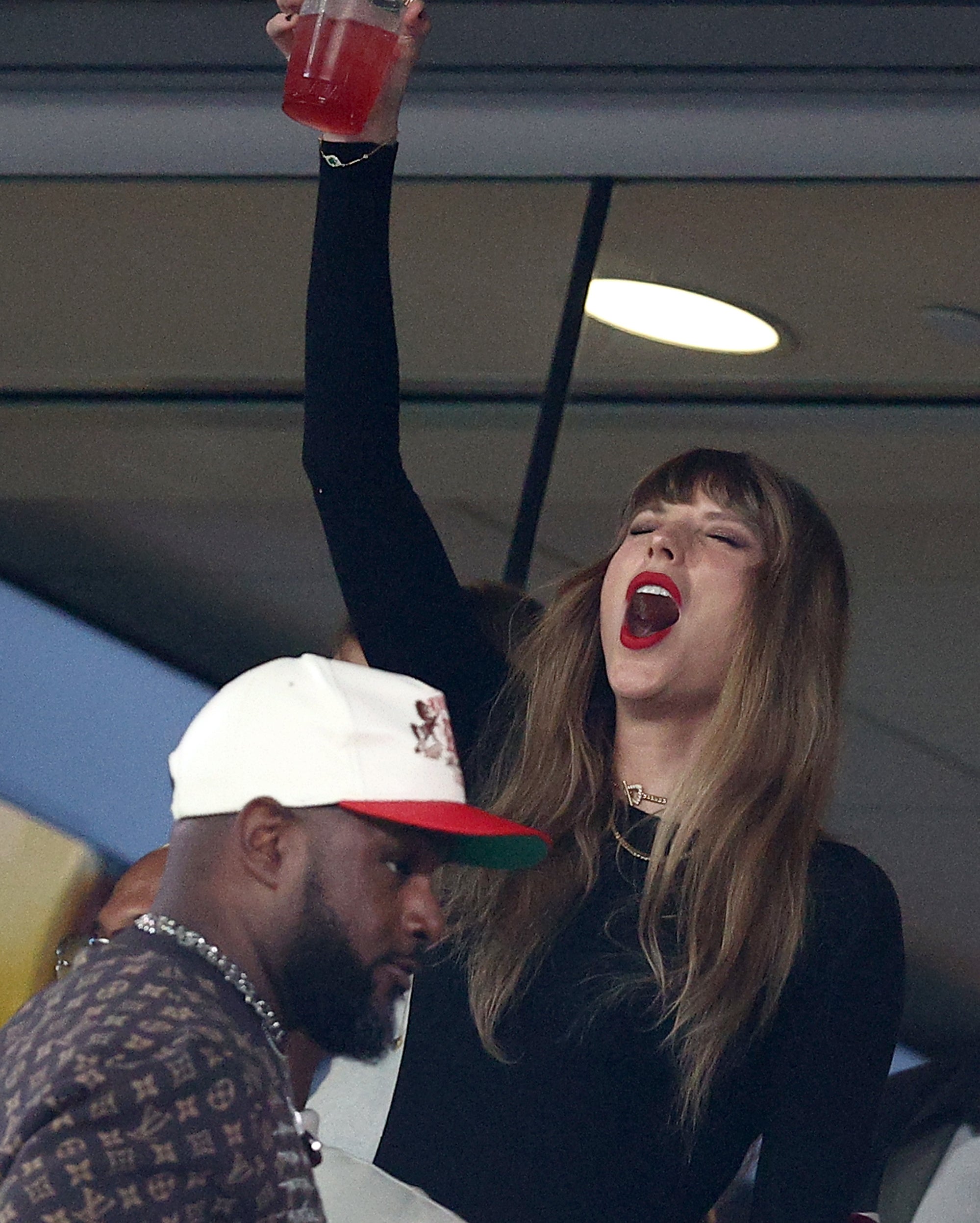taylor cheering and putting a drink in the air