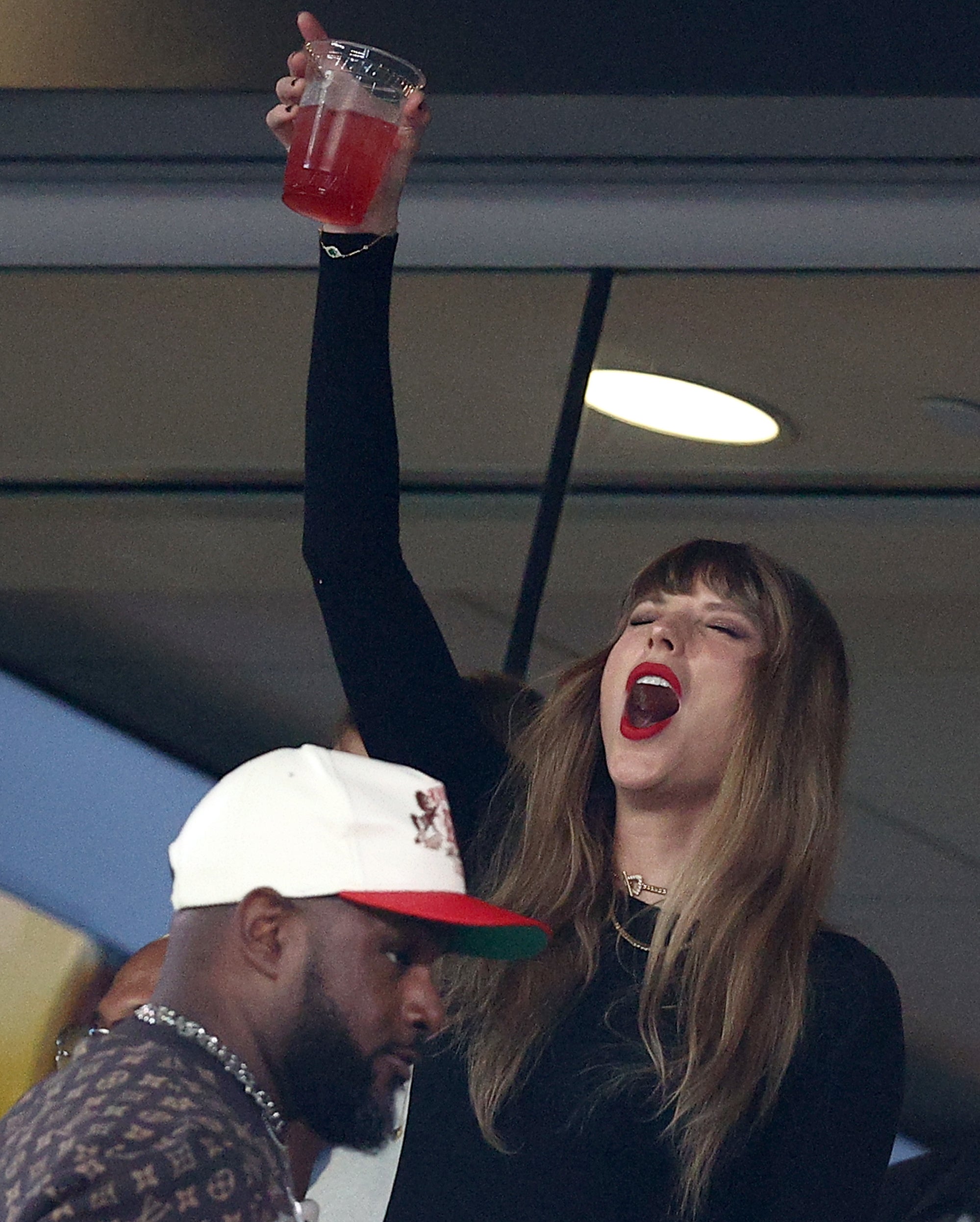 taylor cheering and putting a drink in the air