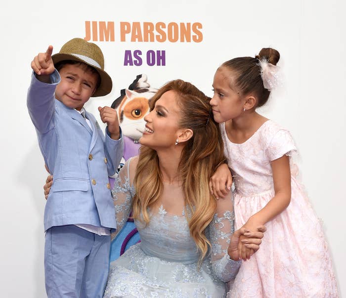 j.lo crouching down next to her kids at an event