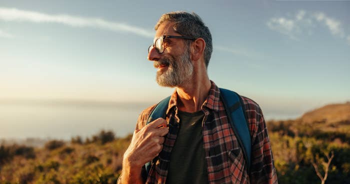 A man hiking near the beach and smiling