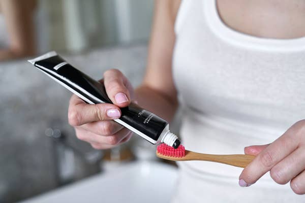 charcoal toothpaste going onto a toothbrush
