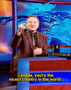 Robin Williams sits behind a anchor reporting desk and says &quot;Canada, you're the nicest country in the world.&quot;