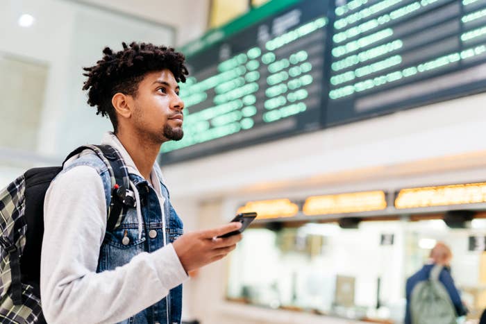 A man in an airport with his phone in his hand