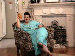 GIF of a woman holding a drink while sitting on a chair