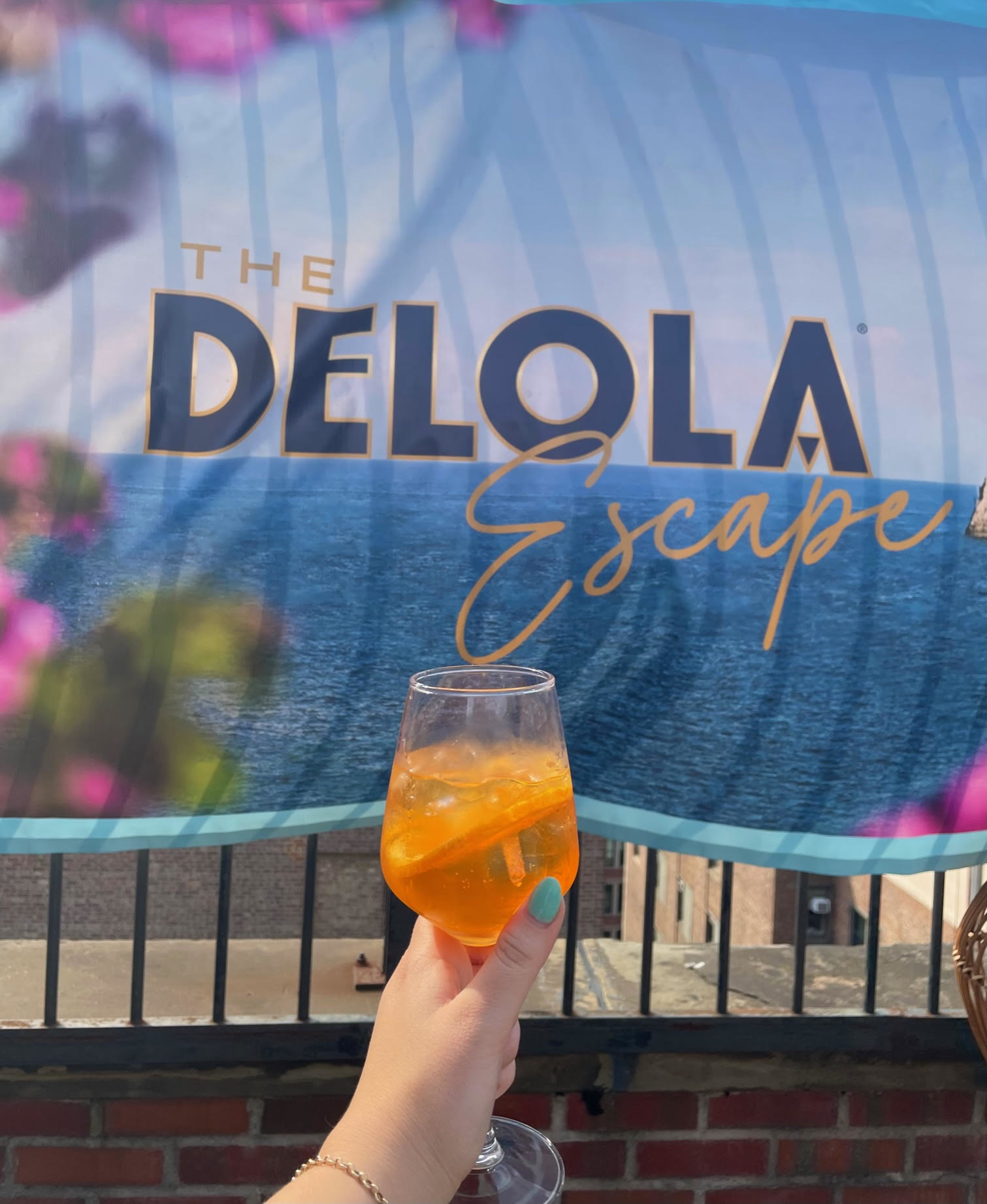 author holding a glass of the drink in front of the brand banner