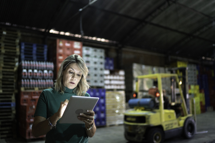 A woman using an iPad in a warehouse