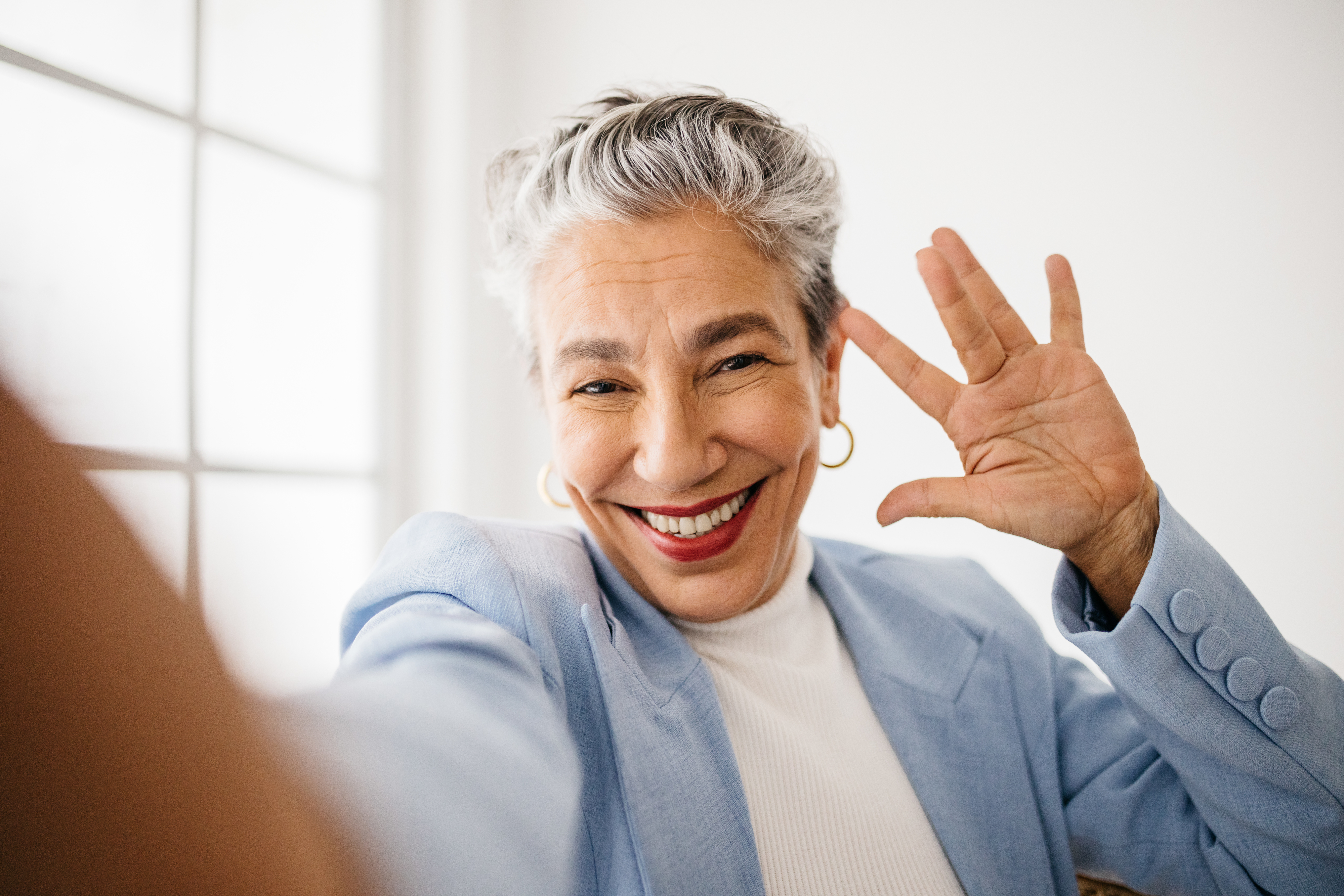 a woman with gray hair posing and smiling