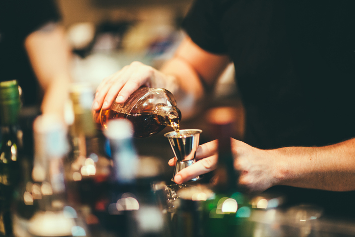 A bartender pouring a shot