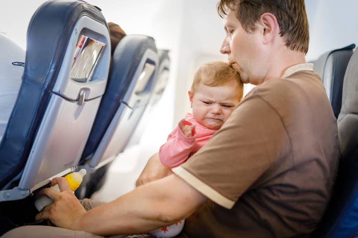A man comforting a fussy baby on a plane