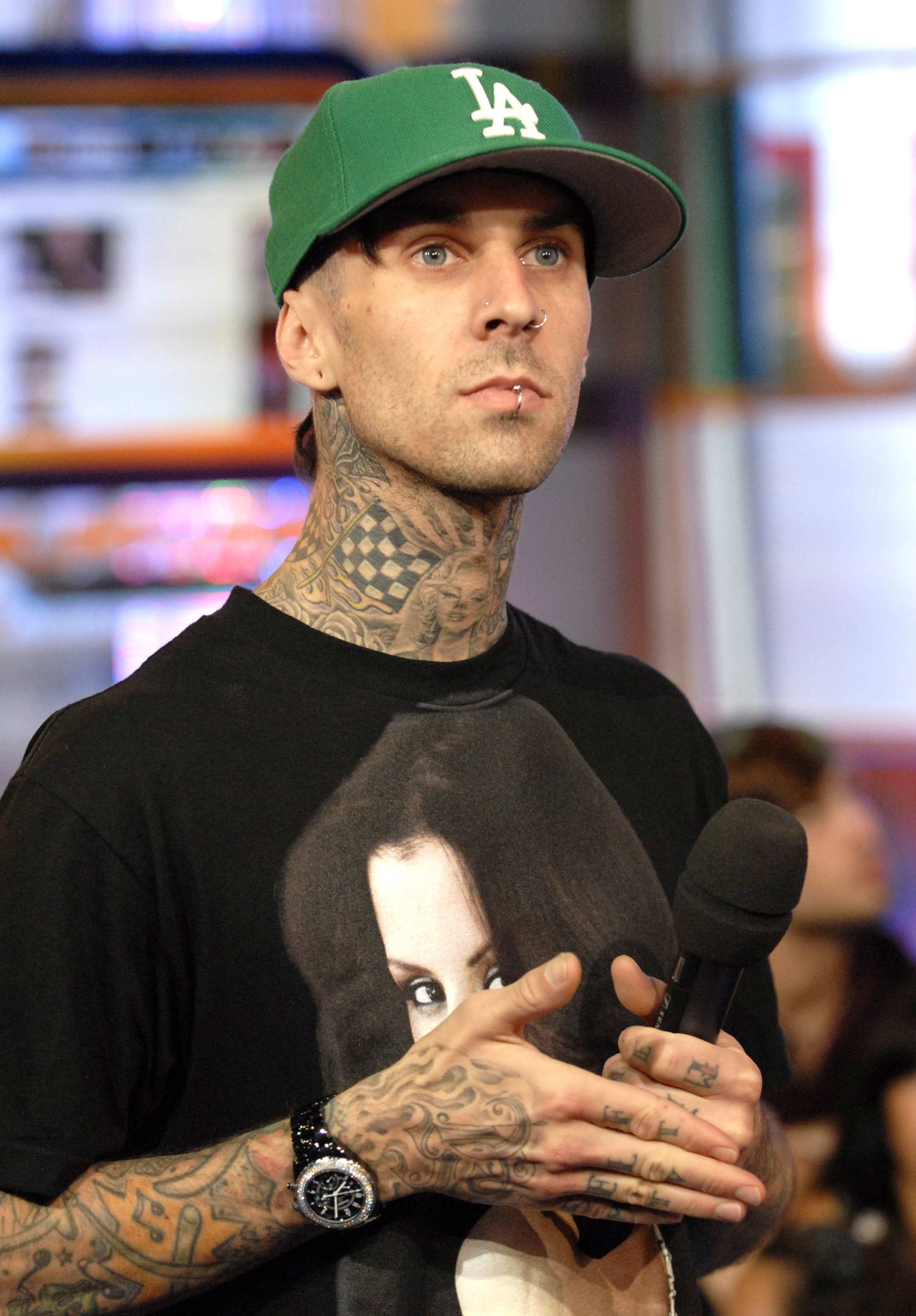 Close-up of Travis holding a microphone and wearing a cap