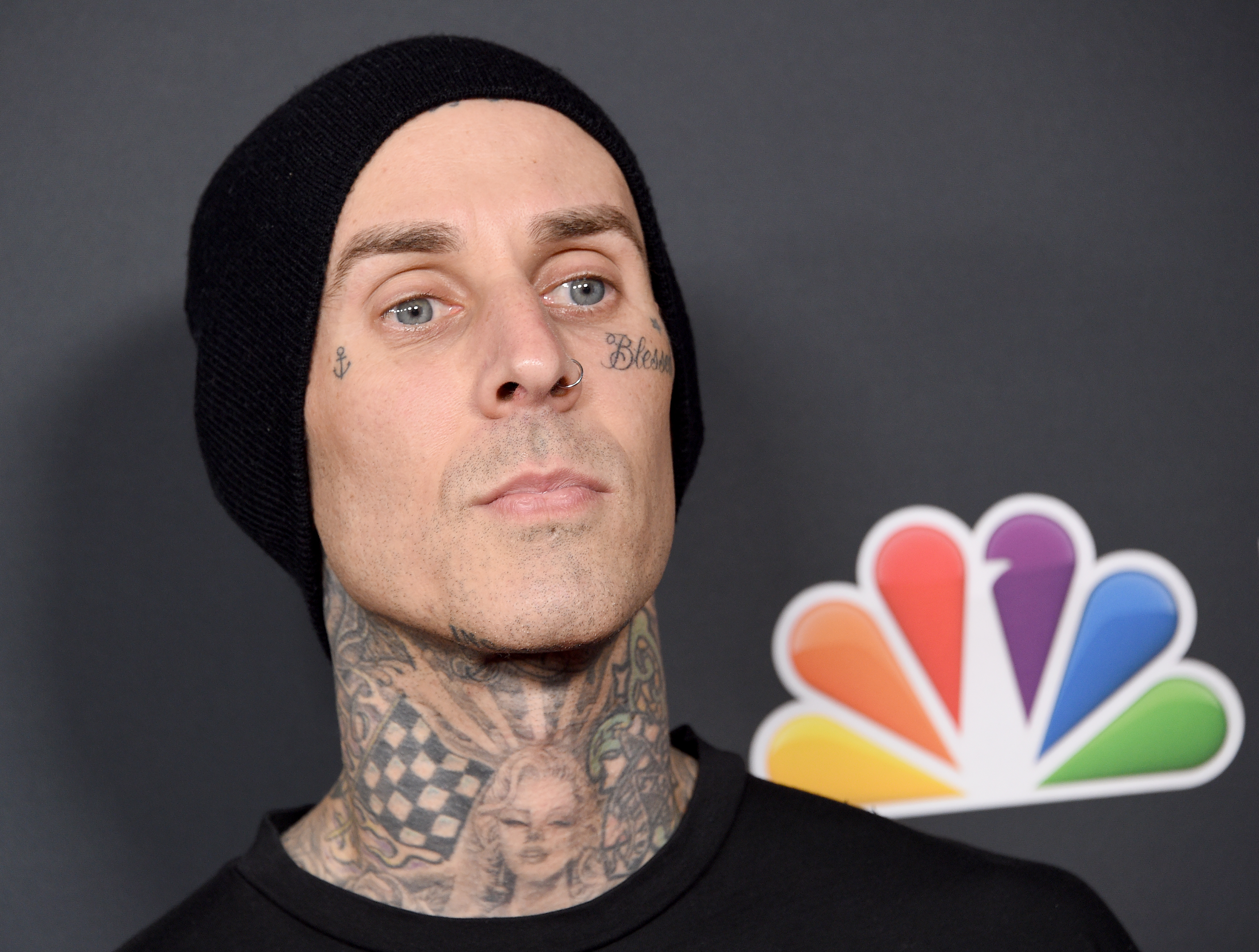Close-up of Travis wearing a beanie at a media event