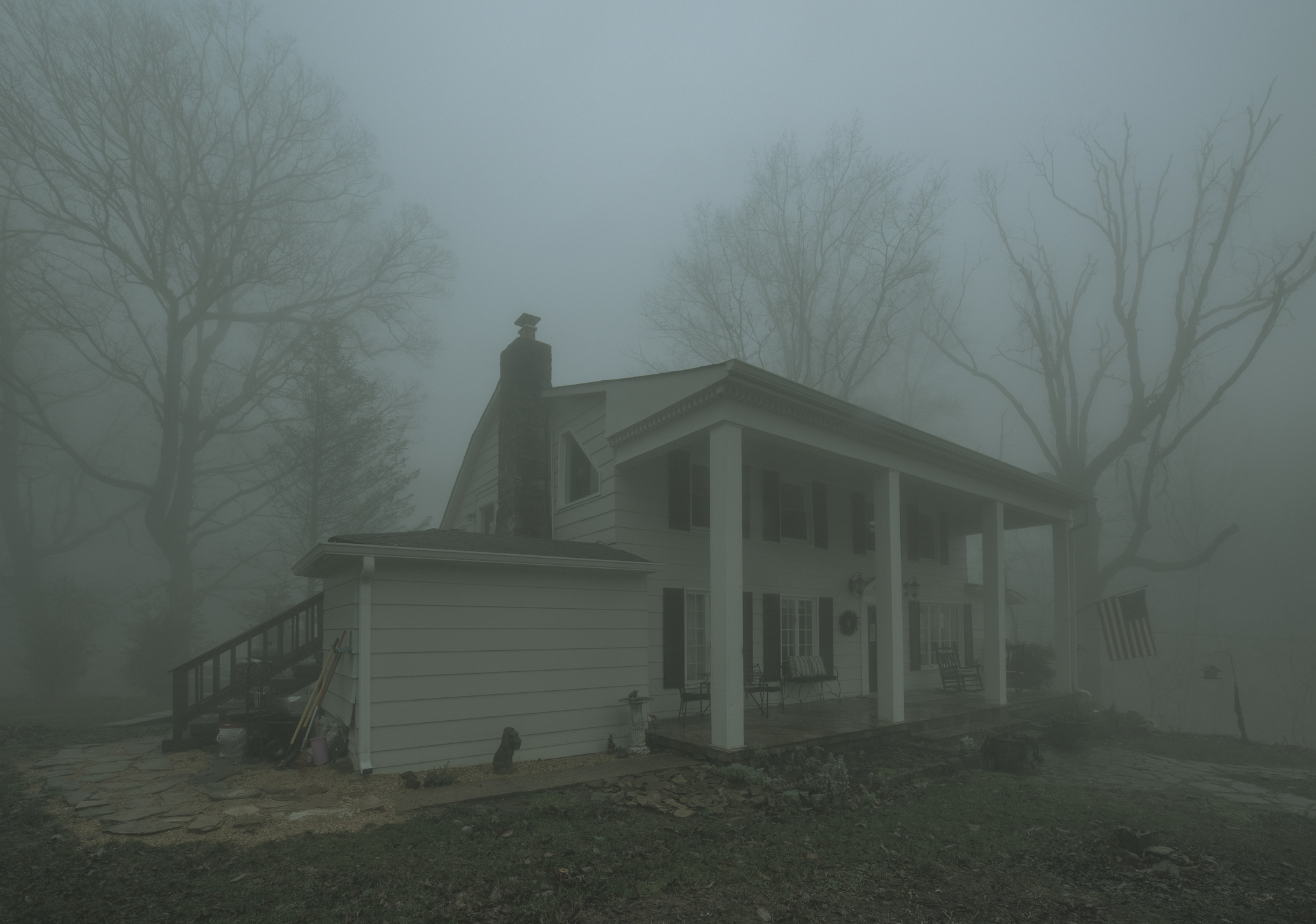 A spooky-looking house is shrouded in fog