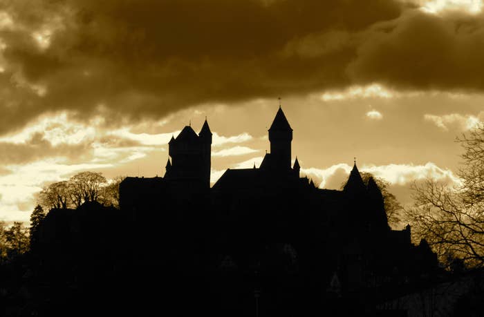 The silhouette of a castle under a yellowish sky