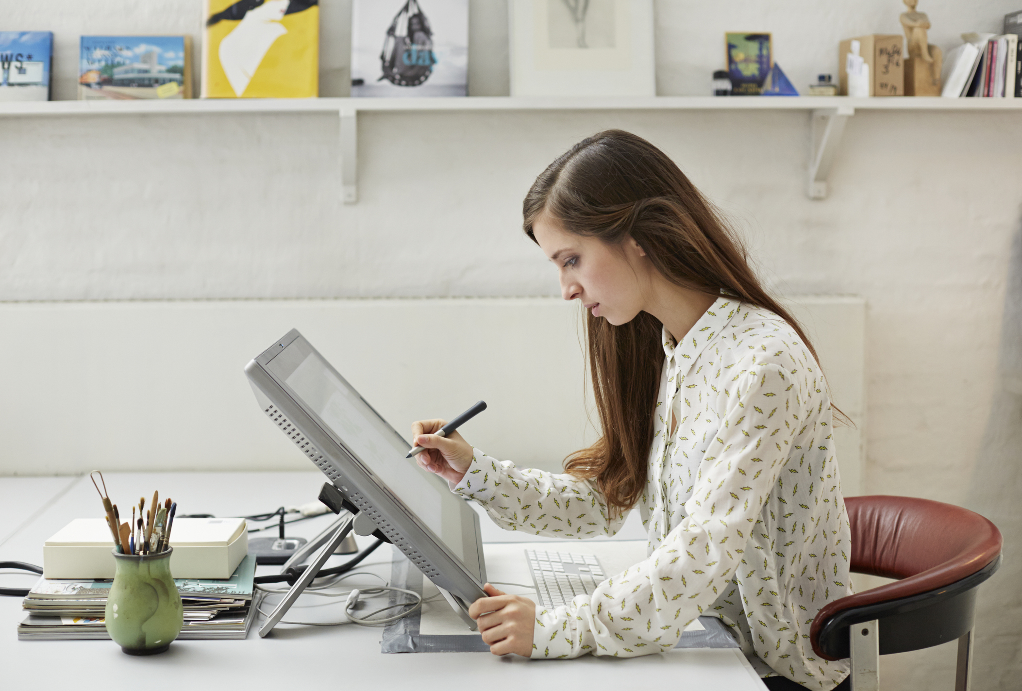 A woman designing on a tablet at her desk