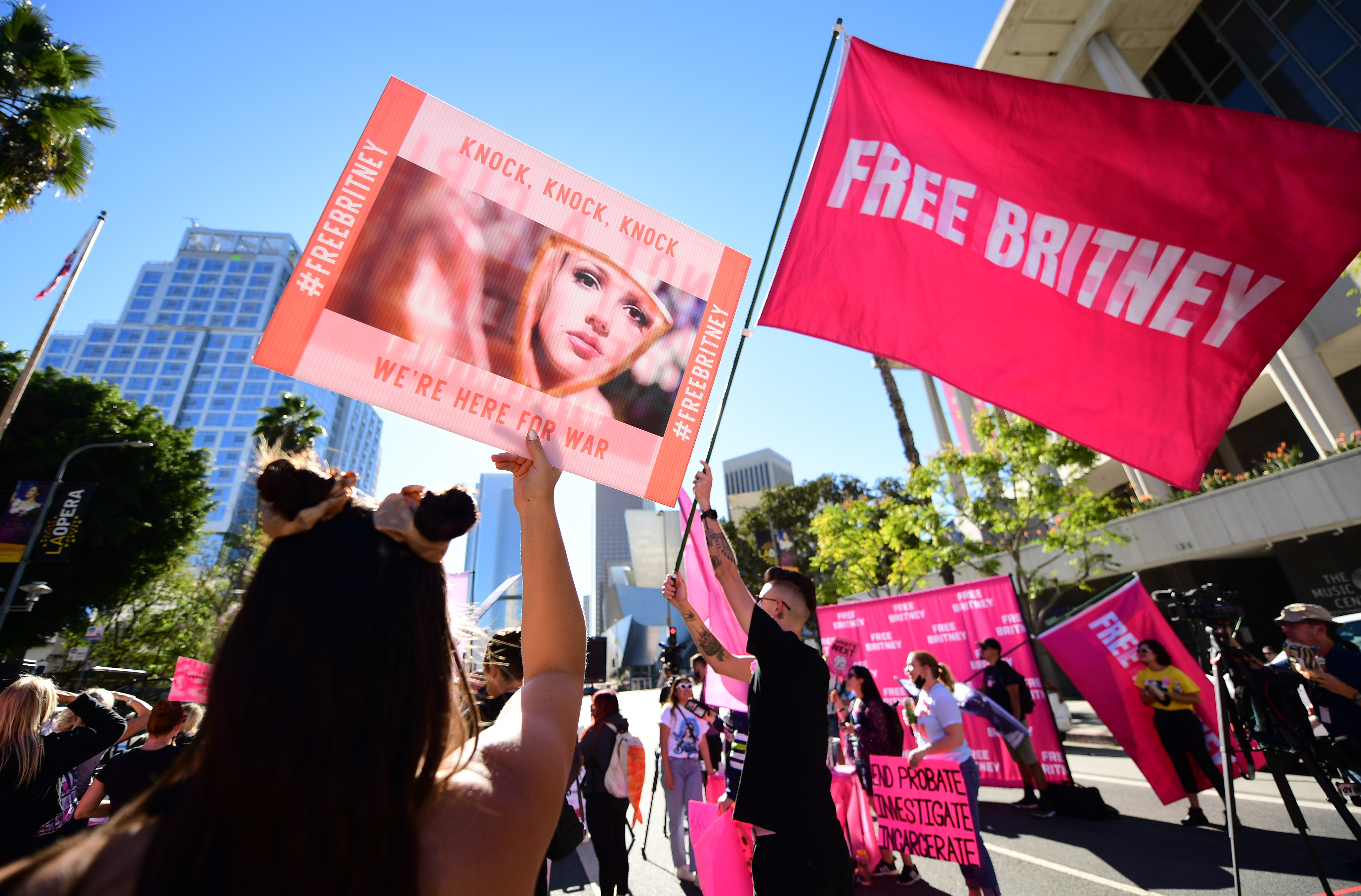 people outside a courthouse holding up free britney signs