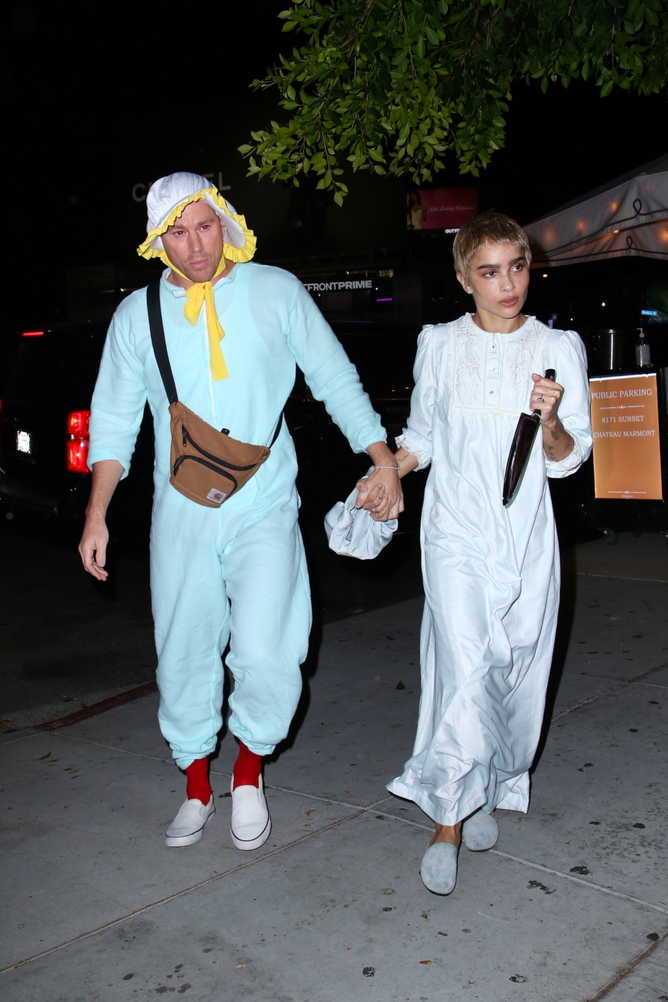 the two holding hands as they walk to a party in their costumes