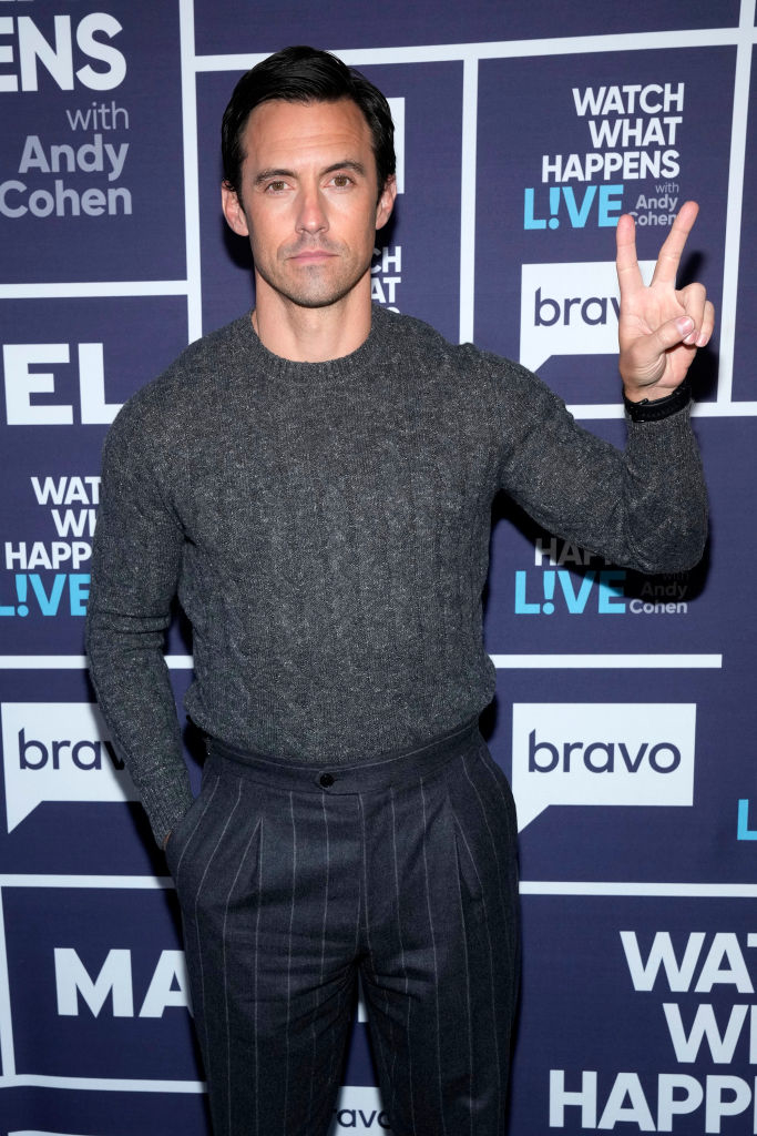 A closeup of Milo Ventimiglia giving the peace sign on the red carpet