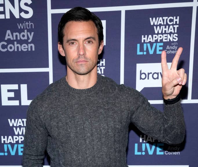 A closeup of Milo Ventimiglia giving the peace sign on the red carpet