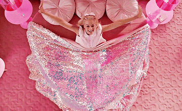 Barbie waking up in her glittery pink bed