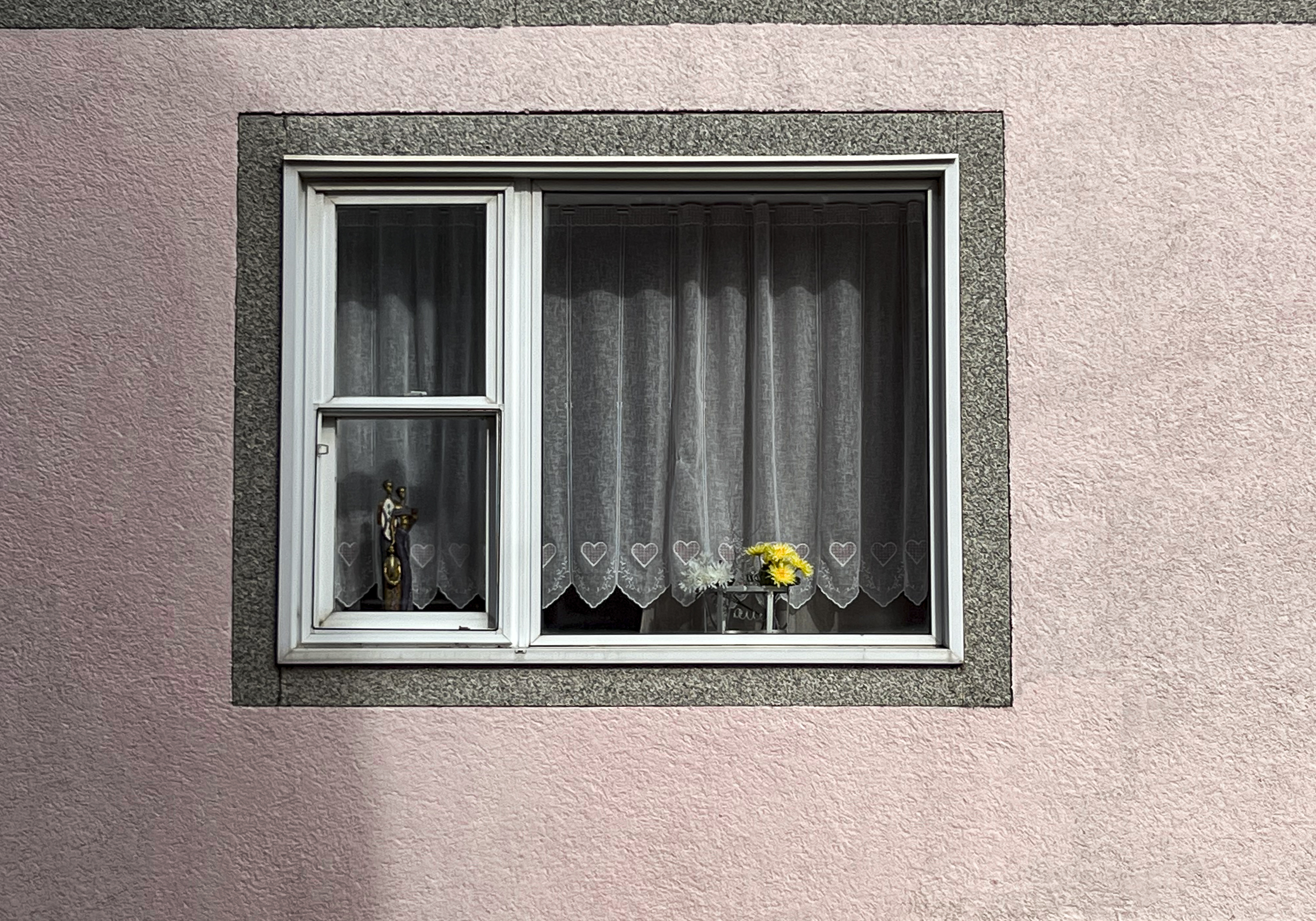 a singular small window with the curtain drawn