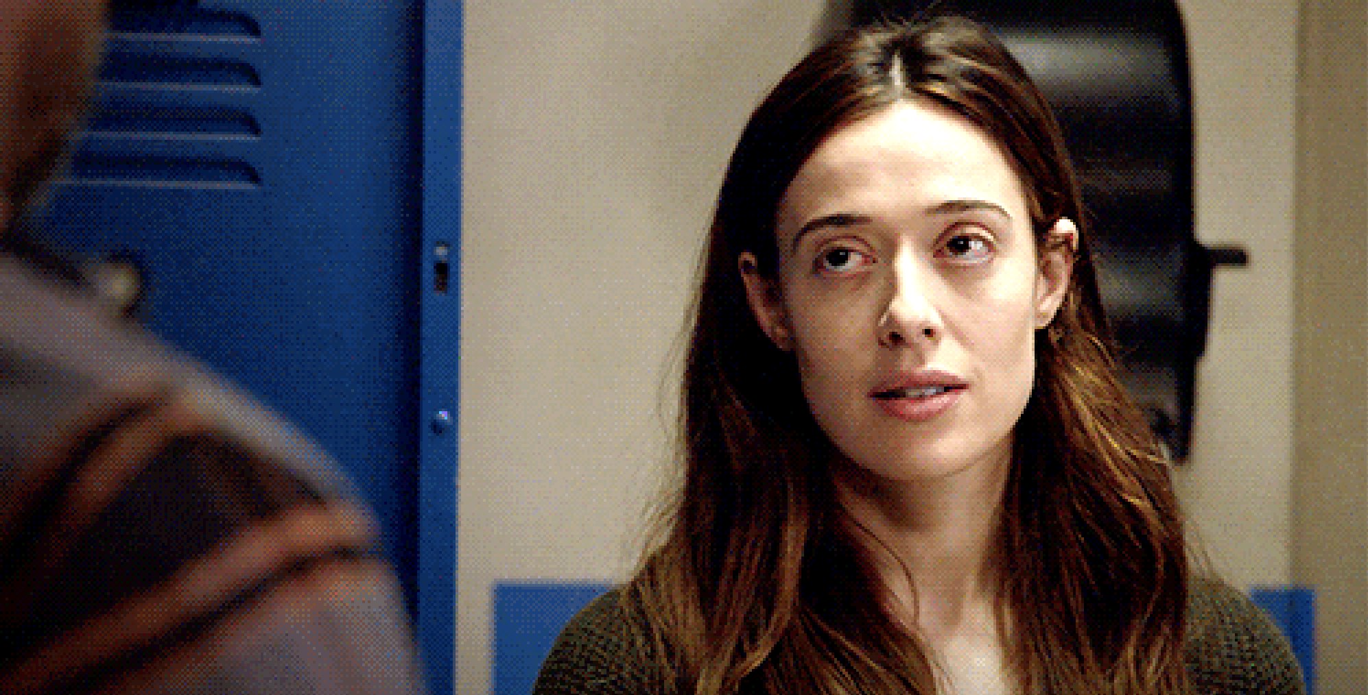 a woman looking nervously at a man she's talking to