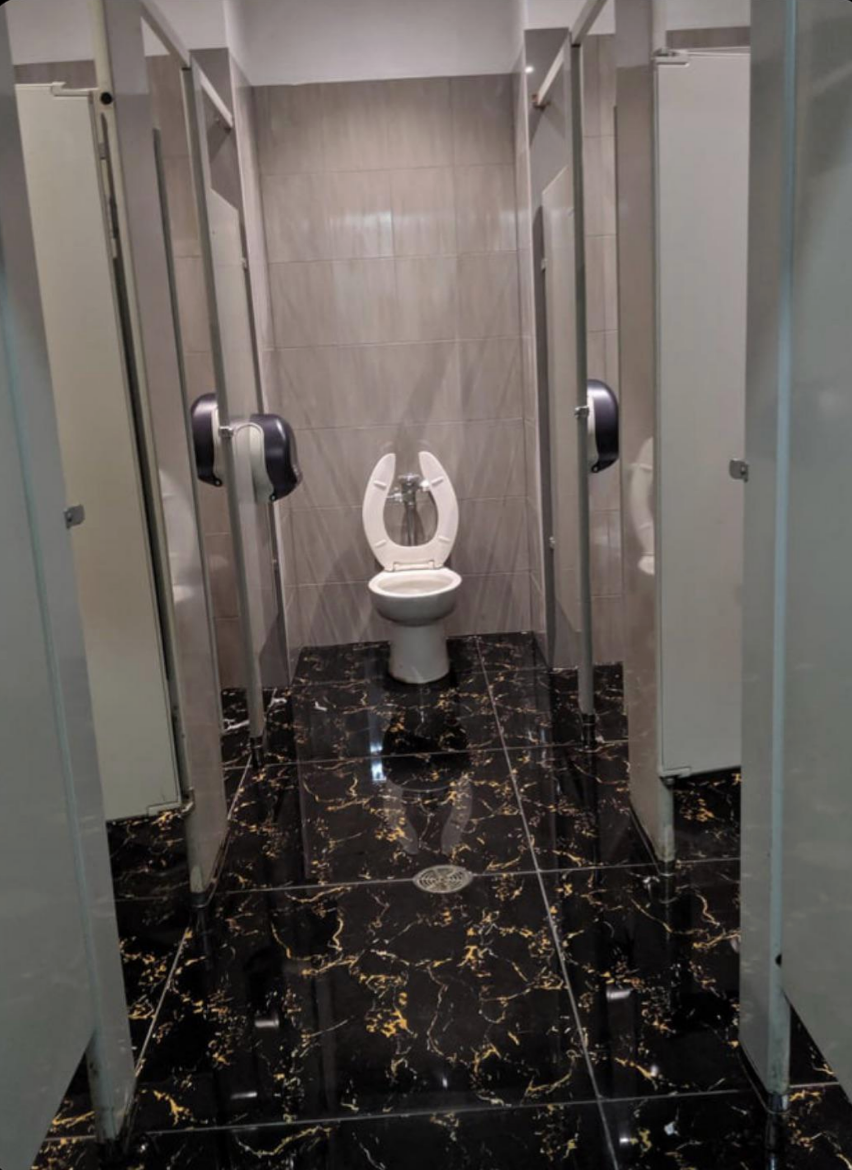 toilet put at the end of the hall in the bathroom, not in a stall