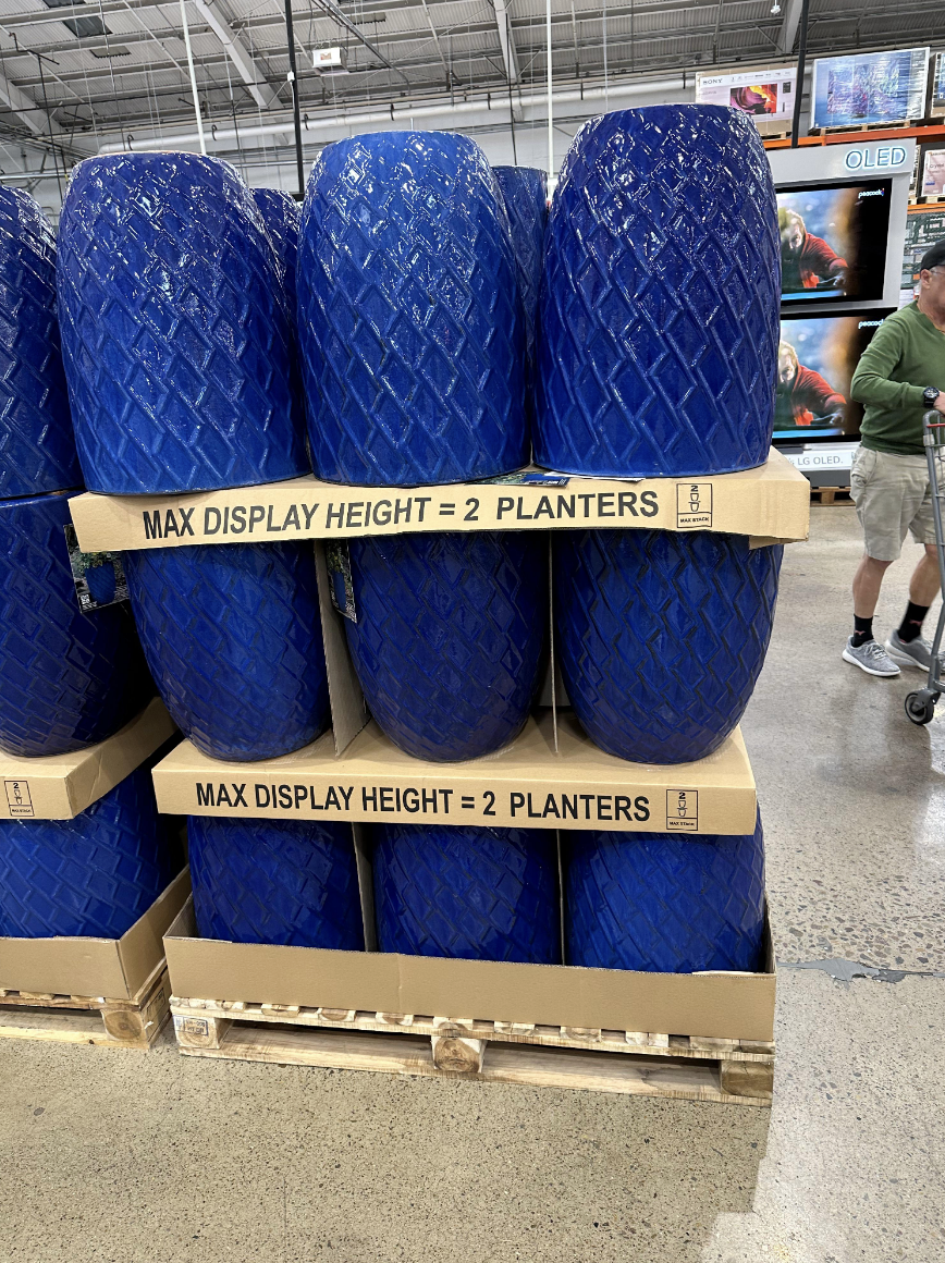 rows of planters on display on top of direction that read only 2 planters should be on top