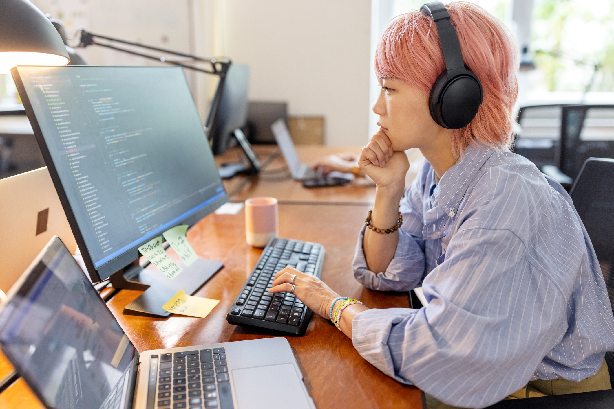 A woman working on multiple computers