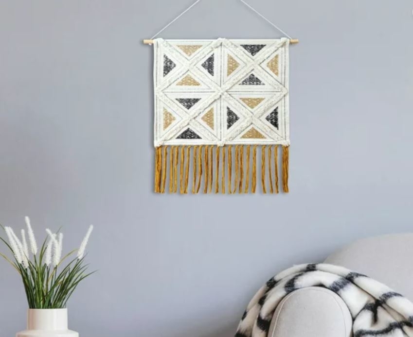 yellow, white and black macrame wall hanging with tassles