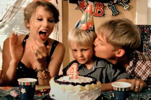 Taylor Swift clapping as her son blows out candles on a birthday cake and her husband kisses their son on the cheek in the Mine music video