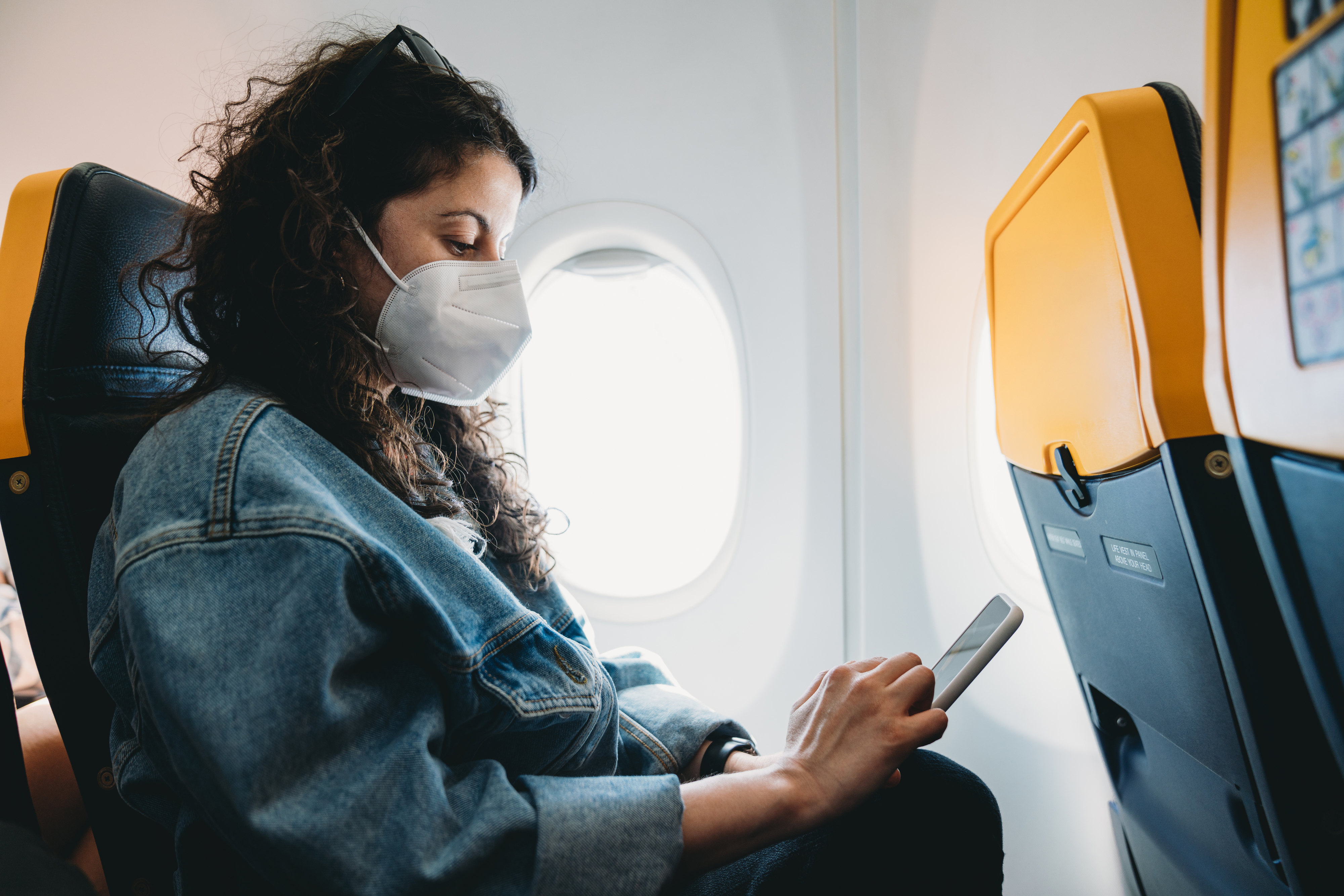 woman wearing a kn95 mask on an airplane