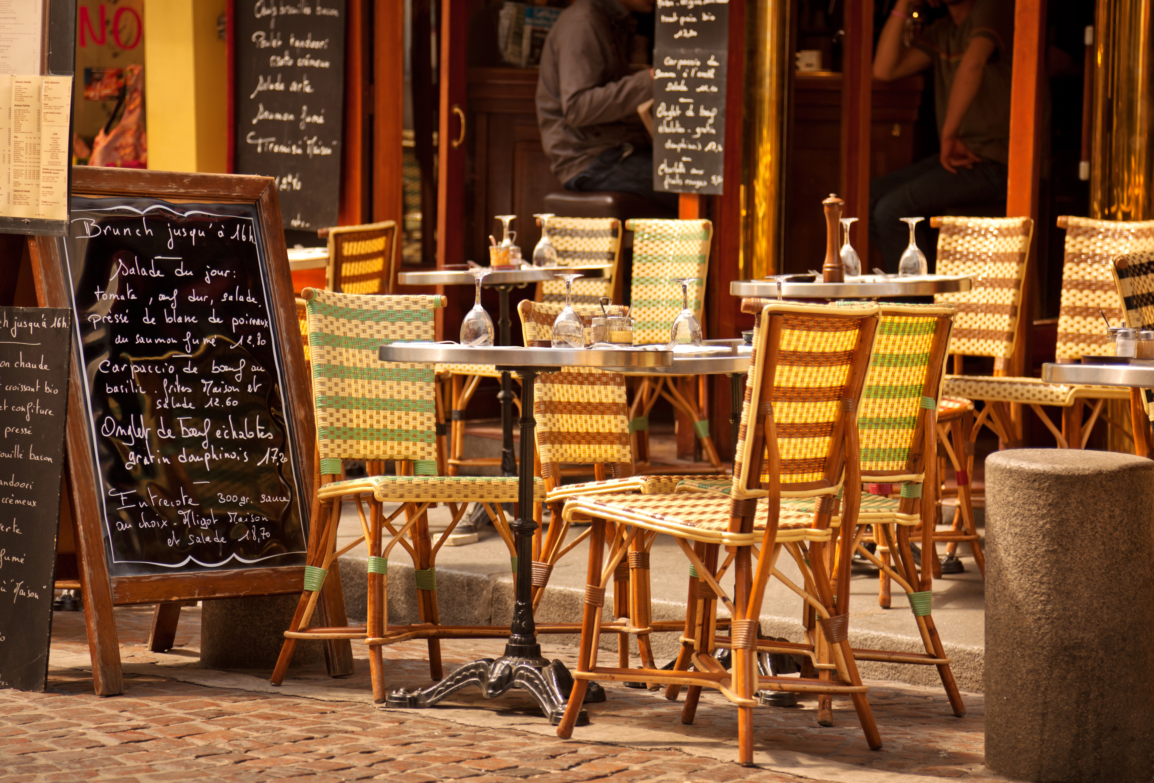colorful tables and chairs outside of a cafe in Paris, France
