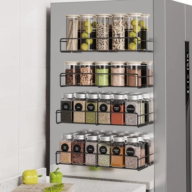 the spice rack mounted on a wall filled with different herbs and spices