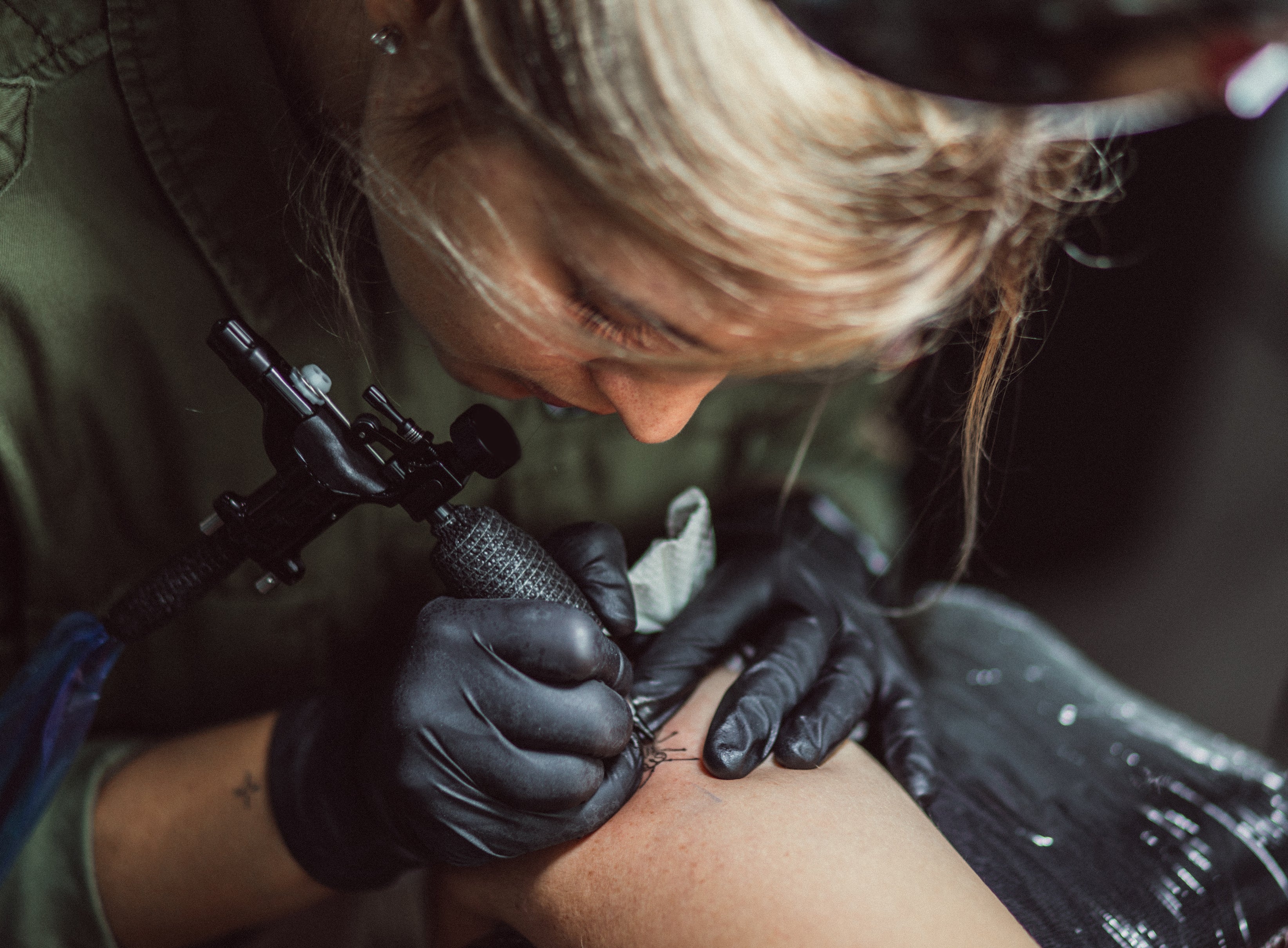 woman tattoo a client&#x27;s arm