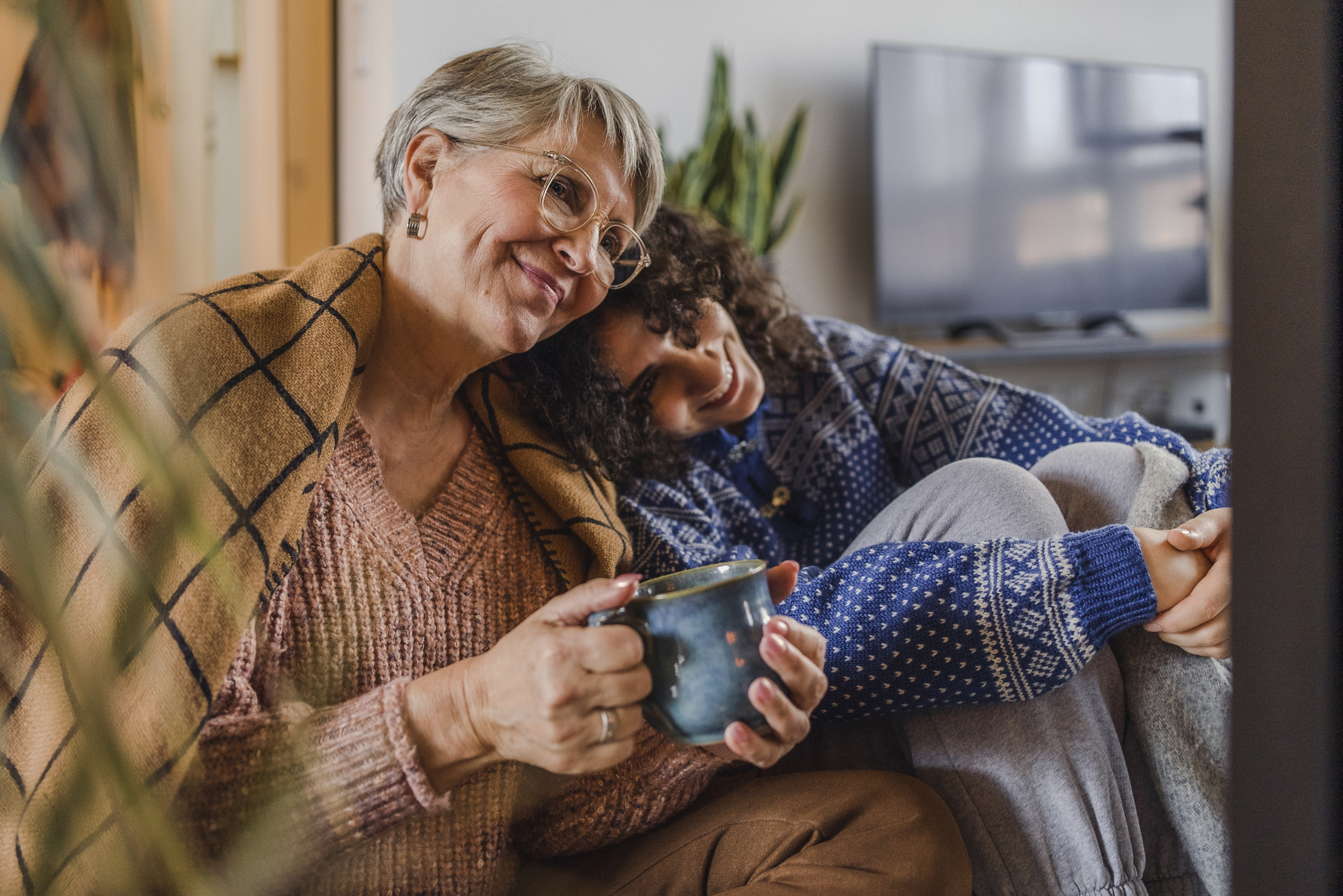 A woman sitting with her grandmother in an affectionate way