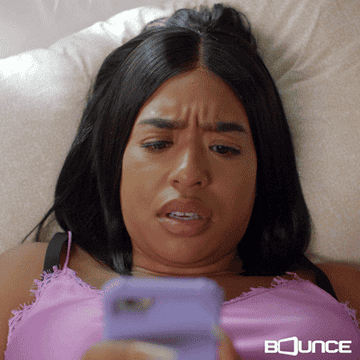 woman staring at her phone suprised