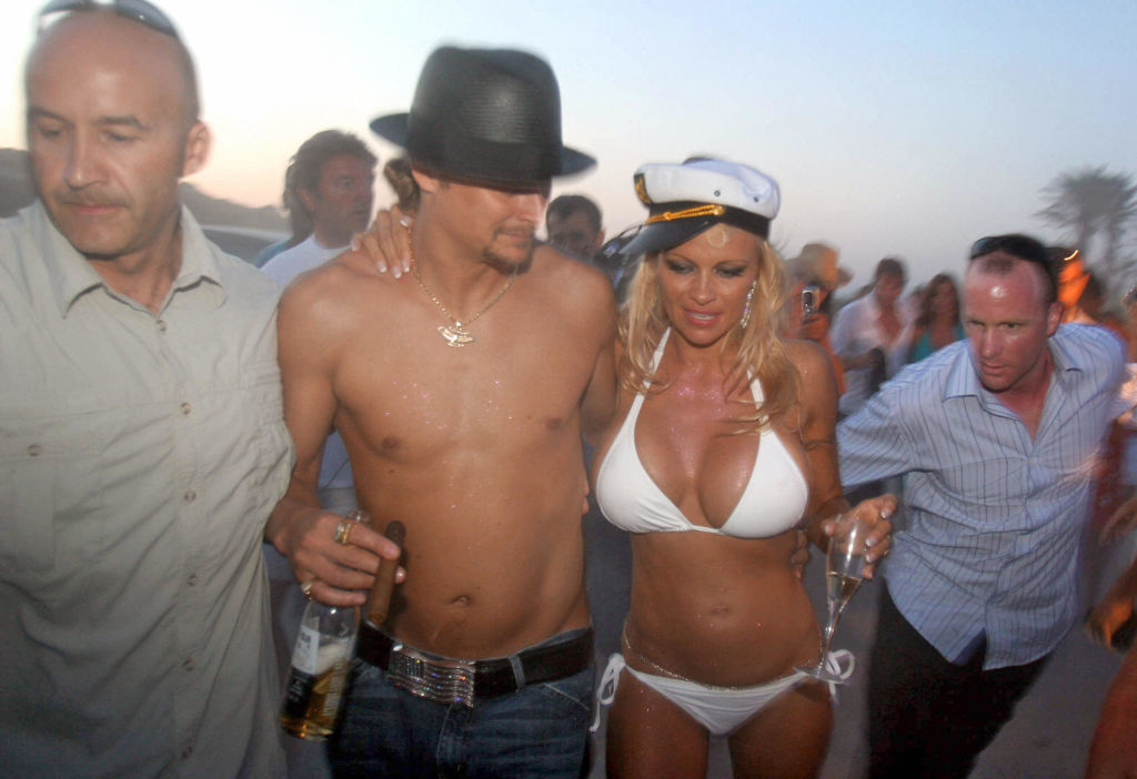 kid rock and pamela holding drinks and surrounded by friends