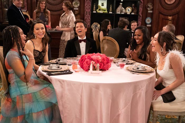 the characters sitting at a round dinner table