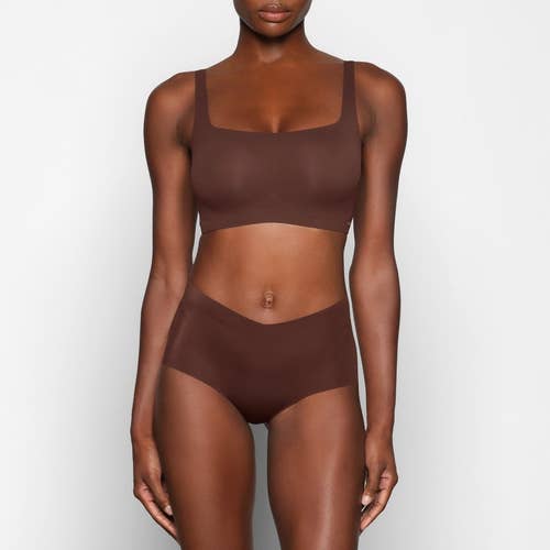 model posing in deep brown nude bra set