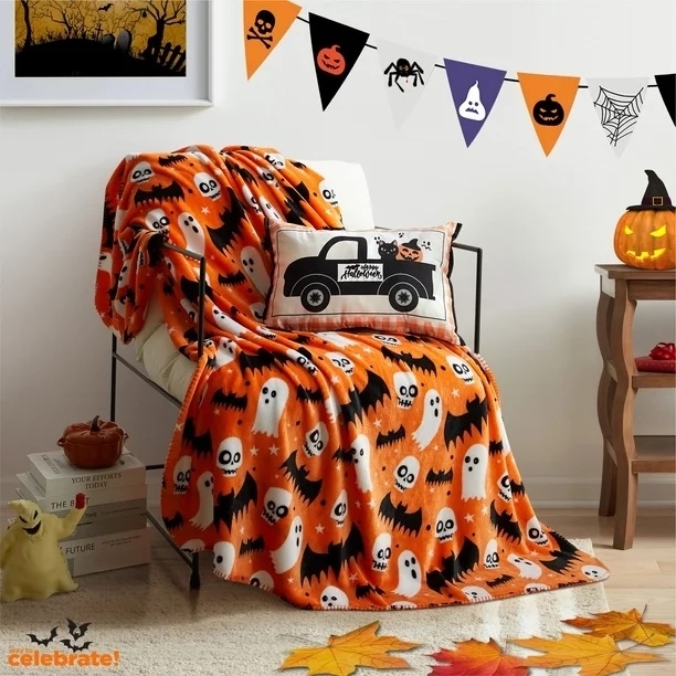 An organge blanket with ghosts and bats on it
