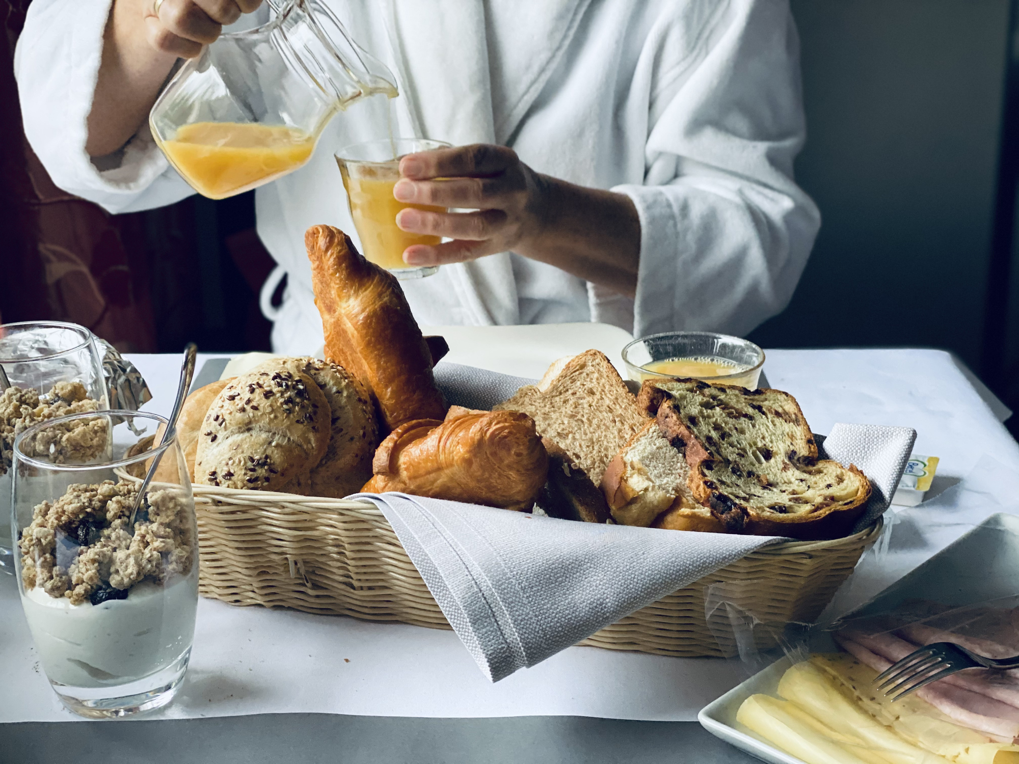 someone pouring themselves orange juice while in a robe