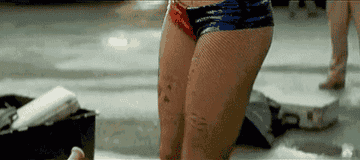 camera scans her body as she dresses in front of a crowd