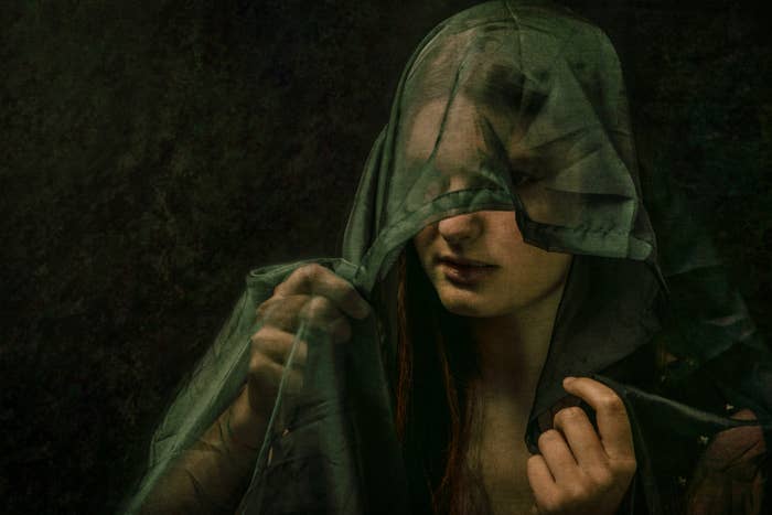 painting of a woman's head and shoulders with a veil over her face