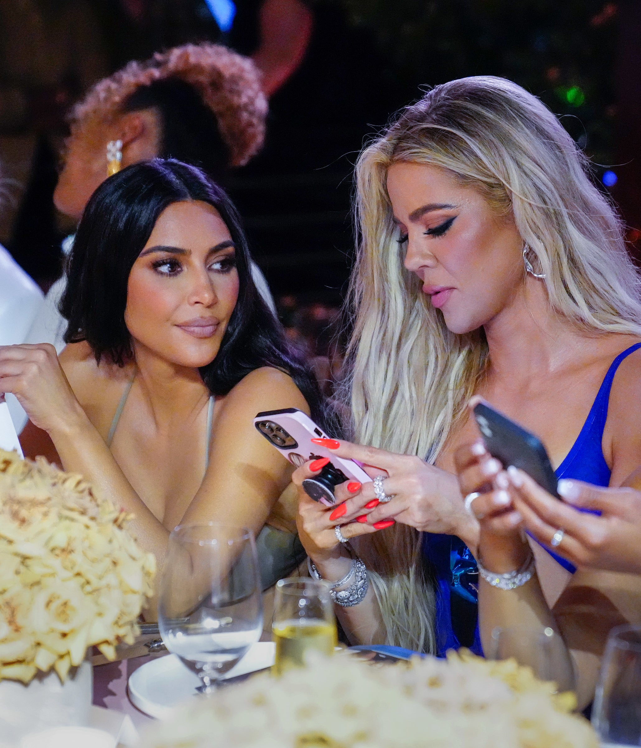 closeup of kim and khloe at a dinner table