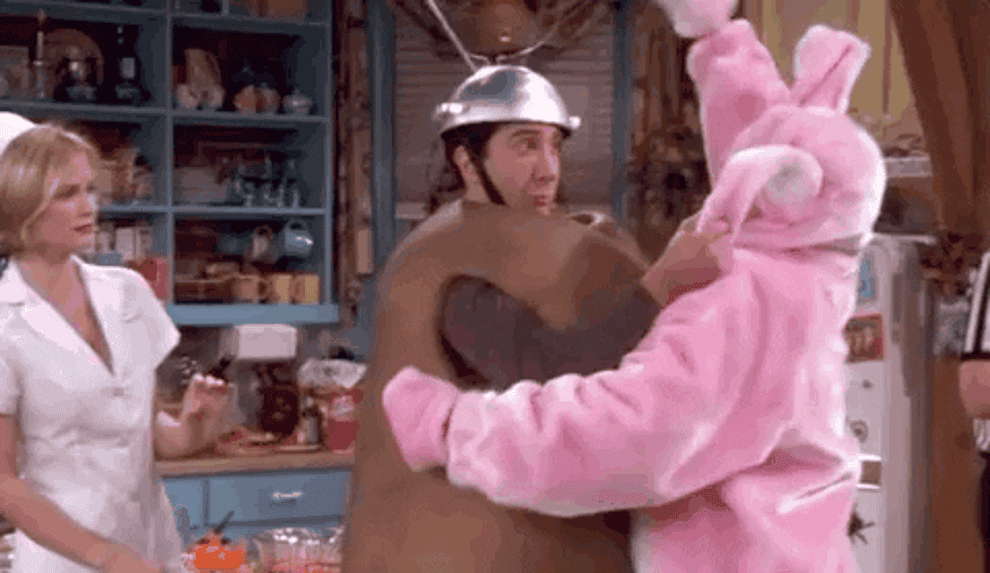 Chandler in a bunny costume hitting Ross who is in a Spudnik costume.