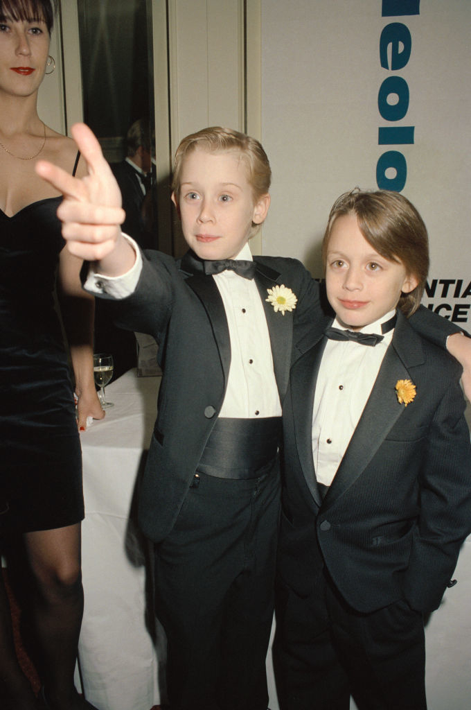 As a child with his brother, both in tuxedos and bow ties